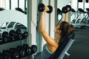 Woman working out with dumbbells in gym photo