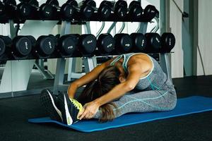 Sporty woman doing stretching exercise in the gym photo