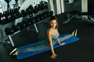 Sporty woman doing stretching exercise in the gym photo