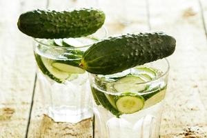 Detox water with cucumber on wooden table photo