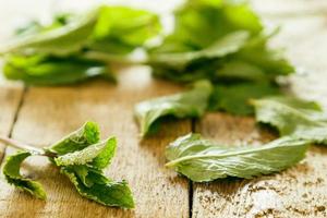 Leaves of fresh mint on wooden table photo