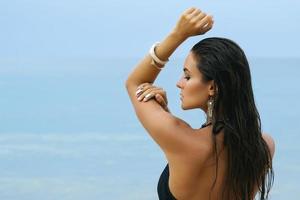 mujer con joyas de plata en la playa foto