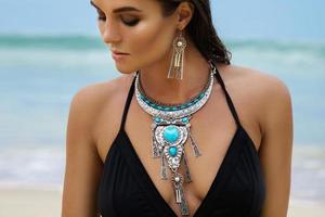 mujer con joyas de plata en la playa foto