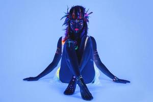 Model in image of Native american with neon makeup, which made of fluorescent paint in ultraviolet light. photo