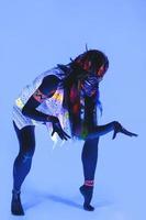 Model in image of Native american with neon makeup, which made of fluorescent paint in ultraviolet light. photo