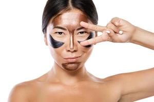 Young asian woman with a purifying peel-off mask on her face photo