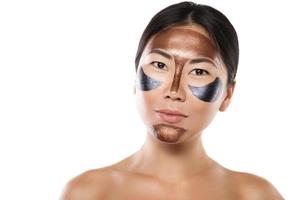 Young asian woman with a purifying peel-off mask on her face photo