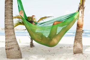 Happy and beautiful woman lying in the hammock photo