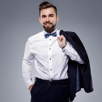 Stylish handsome man wearing a classic suit with bow-tie photo