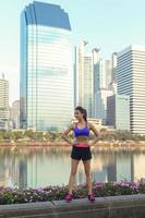 mujer fitness con ropa deportiva en la ciudad moderna con rascacielos foto