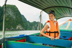 mujer joven en el bote de cola larga durante sus vacaciones en tailandia foto