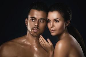 Young beautiful couple in studio on black background photo