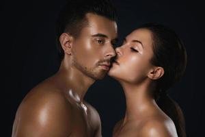 Young beautiful couple in studio on black background photo