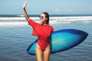 sexy mujer surfista con shortboard en la playa foto