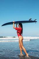 Sexy woman surfer with shortboard on the beach photo