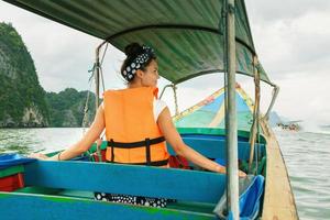 mujer joven en el bote de cola larga durante sus vacaciones en tailandia foto