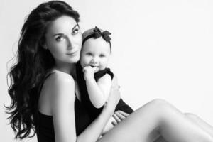 Young mother and her beautiful daughter in studio photo