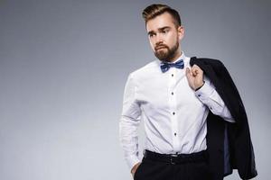 Stylish handsome man wearing a classic suit with bow-tie photo