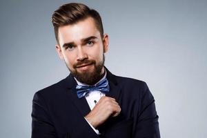 Stylish handsome man wearing a classic suit with bow-tie photo