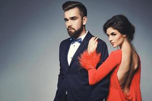 mujer con hermoso vestido rojo y hombre con traje clásico azul con pajarita. foto