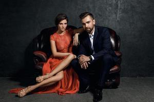 Attractive young couple is sitting on the leather sofa photo