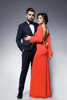 Woman in beautiful red dress and man wearing blue classical suit with bow tie. photo