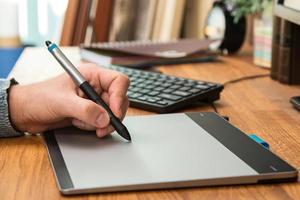 Closeup of male hands during using a graphic tablet photo