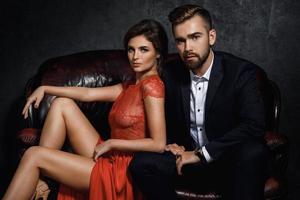 Attractive young couple is sitting on the leather sofa photo