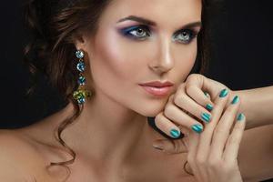Woman with a beautiful makeup and hairstyle wearing shiny earrings photo
