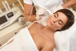 Woman during face skin diagnostic in clinic photo