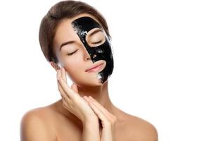 Beautiful woman with a purifying black mask on her face photo