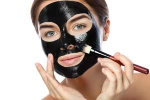 hermosa mujer está aplicando máscara negra purificadora en su cara