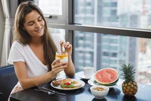 mujer joven desayunando en la mañana en casa foto