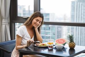 mujer joven desayunando en la mañana en casa foto