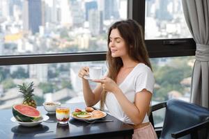 mujer joven desayunando en la mañana en casa foto