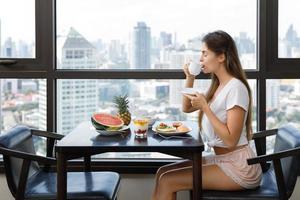 mujer joven desayunando en la mañana en casa foto