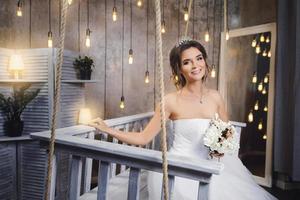 joven novia feliz con un hermoso vestido exuberante en la habitación con muchas bombillas foto