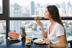 mujer joven desayunando en la mañana en casa foto