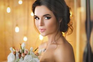 Happy and beautiful bride with bouquet of flowers photo