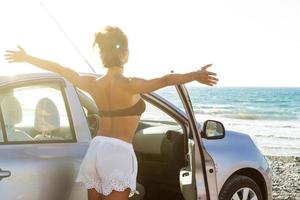 Happy woman and car on the beach photo
