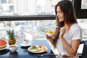 mujer joven desayunando en la mañana en casa foto