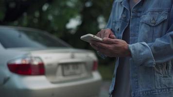 l'homme utilise l'assurance d'informations mobiles via des systèmes d'application. les hommes contactent les concessionnaires automobiles ou les agents d'assurance pour les services d'urgence. assurance et service, appel 24h/24, accident, problème de voiture video