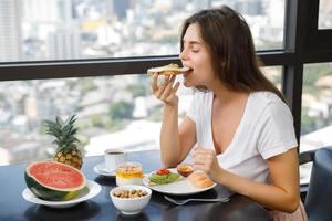 mujer joven desayunando en la mañana en casa foto