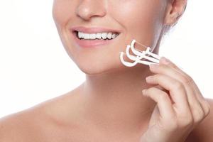 Woman with dental floss pick on white background photo