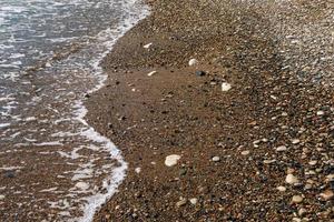 fondo de piedras de guijarros en la playa foto