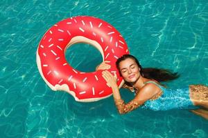 hermosa mujer y anillo de natación inflable en forma de donut foto