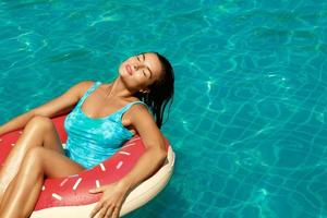 Beautiful woman and inflatable swim ring in shape of donut photo
