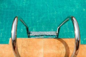 escalera en la piscina con hermosa agua limpia foto