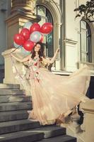 Woman in beautiful dress with a lot of colorful balloons photo