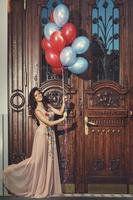 mujer con un hermoso vestido con muchos globos de colores foto